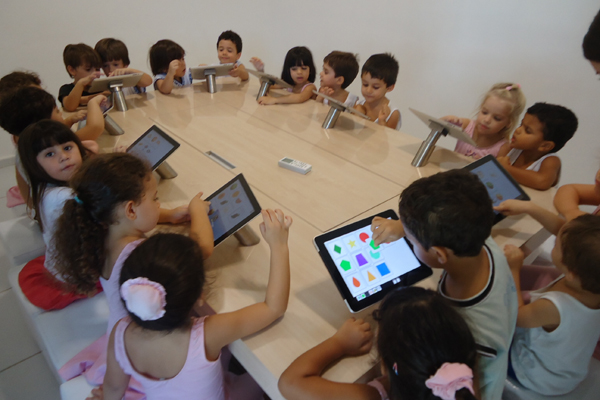 Crianças usando tablets em sala de aula